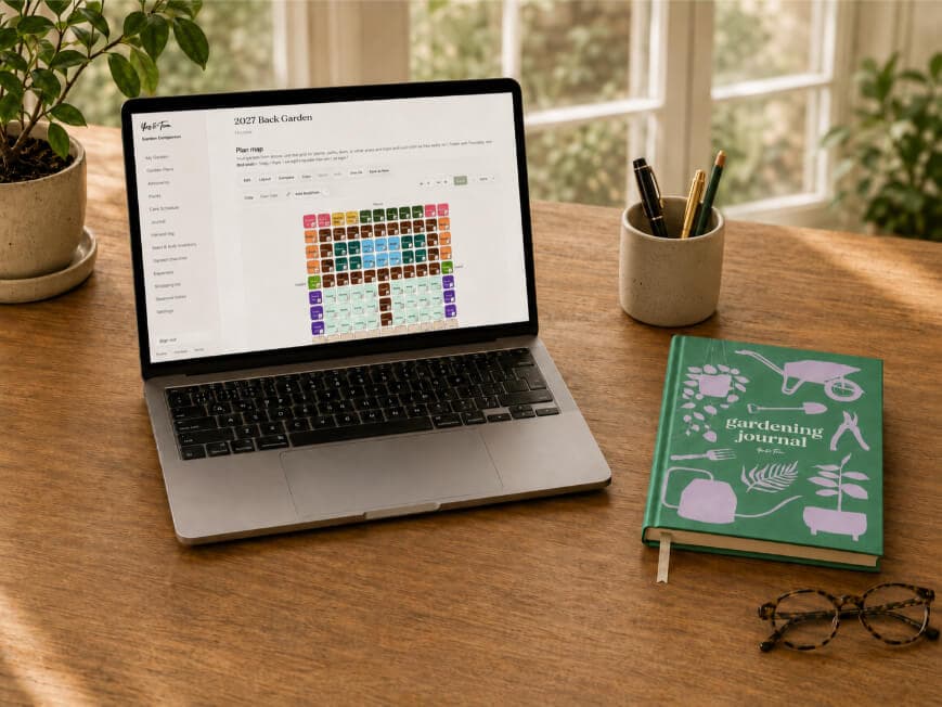 Garden Companion on a laptop beside the Yop & Tom Gardening Planner and a potted plant
